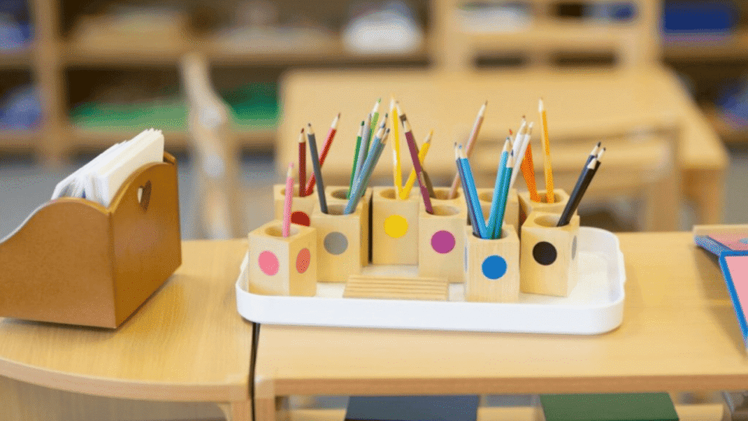 Colorful pencils and pens in a Montessori classroom setting.